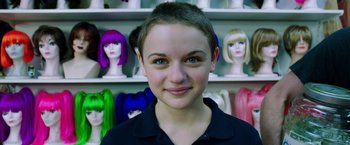 Movie still from “Wish I Was Here” (2014), directed by Zach Braff – A young person with a lot of different colored wigs in the background; Close Up shot, Over the shoulder angle