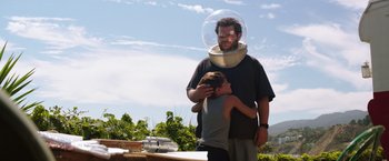 Movie still from “Wish I Was Here” (2014), directed by Zach Braff – A man with a helmet on his head is hugging a boy; Medium shot, Low angle