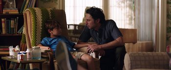 Movie still from “Wish I Was Here” (2014), directed by Zach Braff – A man and a boy sitting in a chair talking to each other; Medium shot, Over the shoulder angle