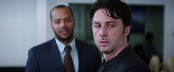 Movie still from “Wish I Was Here” (2014), directed by Zach Braff – Two men standing next to each other wearing suits and ties; Close Up shot, Over the shoulder angle