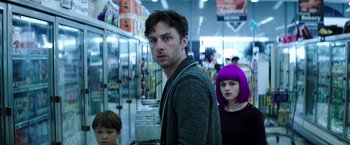 Movie still from “Wish I Was Here” (2014), directed by Zach Braff – A group of people standing in front of a refrigerator; Medium shot, Over the shoulder angle