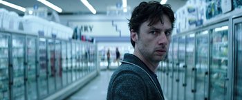 Movie still from “Wish I Was Here” (2014), directed by Zach Braff – A man standing in a room with a bunch of people; Close Up shot, Low angle