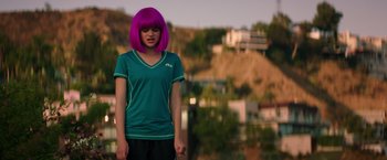 Movie still from “Wish I Was Here” (2014), directed by Zach Braff – A woman with purple hair standing in front of a hill; Medium shot, Over the shoulder angle