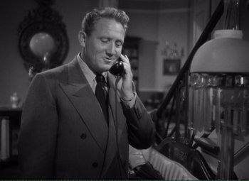 Movie still from “Without Love” (1945), directed by Harold S. Bucquet – A man talking on a cell phone while wearing a suit and tie; Medium shot, Low angle