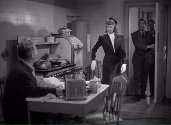 Movie still from “Without Love” (1945), directed by Harold S. Bucquet – An old photo of a man and woman in a kitchen; Medium shot, Over the shoulder angle