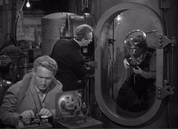 Movie still from “Without Love” (1945), directed by Harold S. Bucquet – A man is looking in the mirror while another man works on a machine; Medium shot, High angle