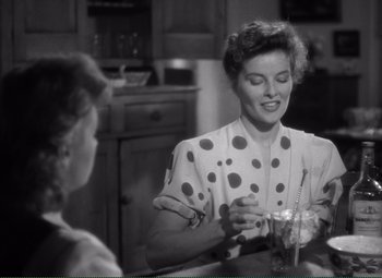 Movie still from “Without Love” (1945), directed by Harold S. Bucquet – A woman in a polka dot shirt is holding a glass; Medium shot, Over the shoulder angle