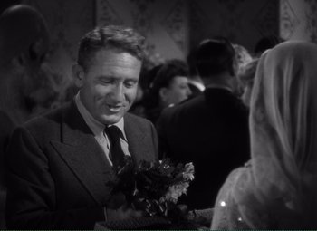 Movie still from “Without Love” (1945), directed by Harold S. Bucquet – A black and white photo of a man holding a bouquet of flowers; Close Up shot, Over the shoulder angle