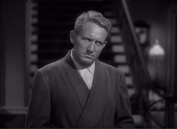 Movie still from “Without Love” (1945), directed by Harold S. Bucquet – A man in a suit and tie standing in front of stairs; Close Up shot, Over the shoulder angle