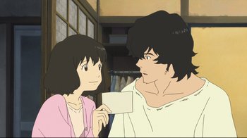 Movie still from “Wolf Children” (2012), directed by Mamoru Hosoda – An animated picture of a man and a woman holding a piece of paper; Medium shot, Over the shoulder angle