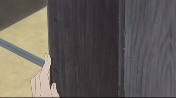 Movie still from “Wolf Children” (2012), directed by Mamoru Hosoda – A hand is holding a piece of wood in front of a wall; Extreme Close Up shot, Low angle