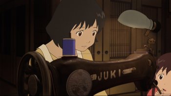 Movie still from “Wolf Children” (2012), directed by Mamoru Hosoda – A girl sitting in front of a sewing machine; Close Up shot, High angle