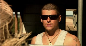 Movie still from “Wolf Creek” (2005), directed by Greg McLean – A person wearing sunglasses; Close Up shot, High angle