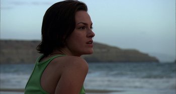 Movie still from “Wolf Creek” (2005), directed by Greg McLean – A beautiful woman standing on the beach in front of the ocean; Close Up shot, Low angle