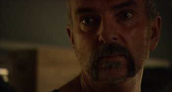 Movie still from “Wolf Creek” (2005), directed by Greg McLean – A person with a beard and mustache; Close Up shot, Over the shoulder angle