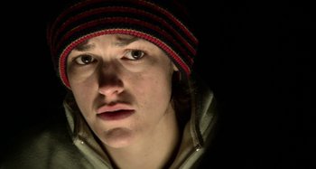 Movie still from “Wolf Creek” (2005), directed by Greg McLean – A person with a hat and a jacket on in the dark; Close Up shot, Low angle