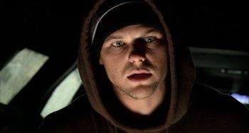 Movie still from “Wolf Creek” (2005), directed by Greg McLean – A person wearing a hooded sweatshirt; Close Up shot, Low angle