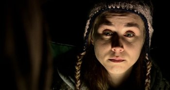 Movie still from “Wolf Creek” (2005), directed by Greg McLean – A woman wearing a hooded jacket looking at the camera; Close Up shot, Over the shoulder angle
