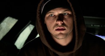 Movie still from “Wolf Creek” (2005), directed by Greg McLean – A person wearing a hooded sweatshirt; Close Up shot, Low angle