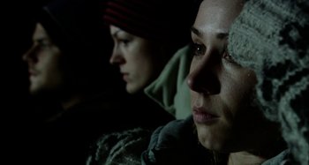 Movie still from “Wolf Creek” (2005), directed by Greg McLean – Two people sitting in a dark room looking at something; Close Up shot, Low angle