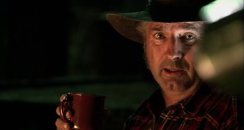 Movie still from “Wolf Creek” (2005), directed by Greg McLean – A person holding a cup of coffee; Close Up shot, Over the shoulder angle