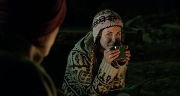 Movie still from “Wolf Creek” (2005), directed by Greg McLean – A woman wearing a hat and holding a mug; Close Up shot, Over the shoulder angle