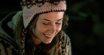 Movie still from “Wolf Creek” (2005), directed by Greg McLean – A woman wearing a hat and smiling for the camera; Close Up shot, Over the shoulder angle