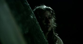 Movie still from “Wolf Creek” (2005), directed by Greg McLean – A woman with long brown hair standing next to a tree; Close Up shot, Low angle