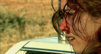 Movie still from “Wolf Creek” (2005), directed by Greg McLean – A person's face covered in bruises; Close Up shot, Over the shoulder angle