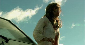 Movie still from “Wolf Creek” (2005), directed by Greg McLean – A woman in a white shirt with blood all over her face; Medium shot, Low angle