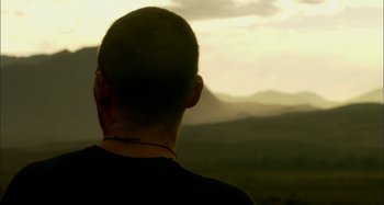 Movie still from “Wolf Creek” (2005), directed by Greg McLean – A man is looking out over a mountain range; Close Up shot, Over the shoulder angle