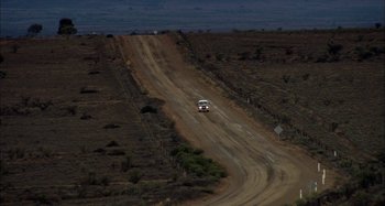 Movie still from “Wolf Creek” (2005), directed by Greg McLean – A truck driving down a dirt road at night; Extreme Wide shot, High angle