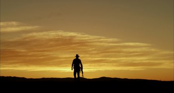 Movie still from “Wolf Creek” (2005), directed by Greg McLean – A man standing on top of a hill at sunset; Extreme Wide shot, Low angle