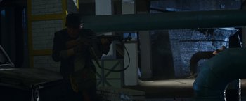 Movie still from “Wolf Warrior 2” (2017), directed by Jing Wu – A man is holding a gun in the dark; Medium shot, Low angle