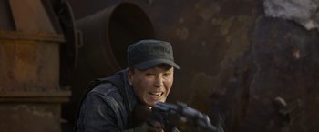 Movie still from “Wolf Warrior 2” (2017), directed by Jing Wu – A man with a gun in his hand and wearing a hat; Close Up shot, Low angle