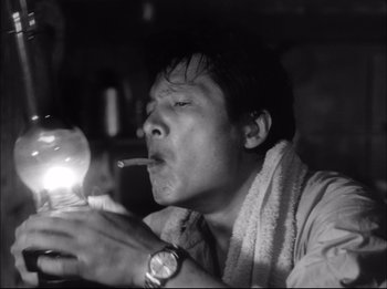 A black and white photo of a man smoking a cigarette