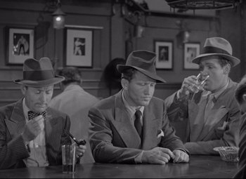 Movie still from “Woman of the Year” (1942), directed by George Stevens – A group of men sitting at a table in front of a glass; Medium shot, High angle
