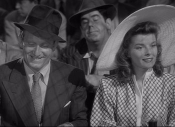 Movie still from “Woman of the Year” (1942), directed by George Stevens – A man and a woman wearing hats in a crowd; Medium shot, High angle