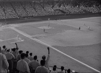 Movie still from “Woman of the Year” (1942), directed by George Stevens – A group of people watching a baseball game in a stadium; Extreme Wide shot, High angle