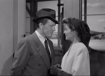 Movie still from “Woman of the Year” (1942), directed by George Stevens – A man and a woman standing next to each other in front of a building; Medium shot, Low angle