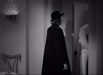 Movie still from “Woman of the Year” (1942), directed by George Stevens – A woman in a black coat and a black hat; Medium shot, Over the shoulder angle