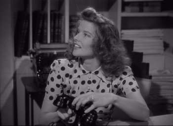Movie still from “Woman of the Year” (1942), directed by George Stevens – A black and white photo of a woman playing a video game; Medium shot, High angle