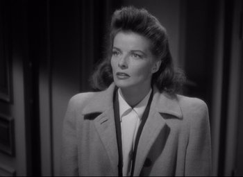 Movie still from “Woman of the Year” (1942), directed by George Stevens – A black - and - white photo of a woman in a coat; Close Up shot, Over the shoulder angle