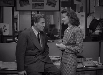 Movie still from “Woman of the Year” (1942), directed by George Stevens – A man and a woman talking to each other in an office setting; Medium shot, High angle