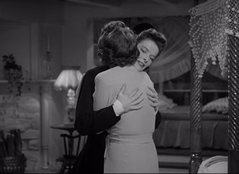 Movie still from “Woman of the Year” (1942), directed by George Stevens – Two women embracing each other in front of a bed; Medium shot, Low angle