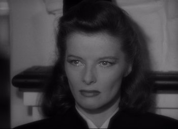 Movie still from “Woman of the Year” (1942), directed by George Stevens – A black - and - white photo of a woman in a suit; Close Up shot, High angle