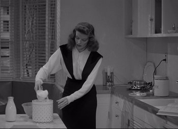 Movie still from “Woman of the Year” (1942), directed by George Stevens – A black and white photo of a woman in a kitchen; Medium shot, Low angle