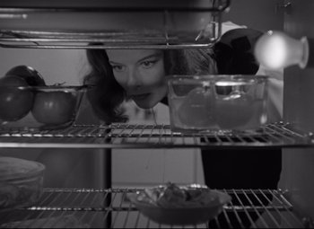 Movie still from “Woman of the Year” (1942), directed by George Stevens – A black and white photo of a woman looking into an oven; Close Up shot, Low angle