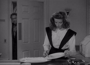 Movie still from “Woman of the Year” (1942), directed by George Stevens – A man and a woman looking at plates on a table; Medium shot, Over the shoulder angle