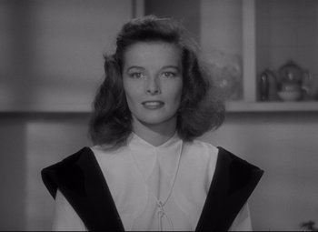 Movie still from “Woman of the Year” (1942), directed by George Stevens – A black - and - white photo of a woman in a white shirt; Close Up shot, Low angle